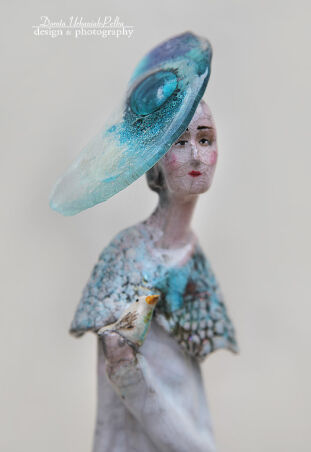 KOBIETA W SZKLANYM KAPELUSZU Z PTASZKIEM